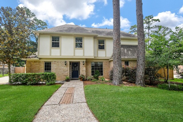 12903 Cluster Pine Dr, Cypress, TX 77429 - tudor-style house featuring stucco siding, roof with shingles, and brick siding
