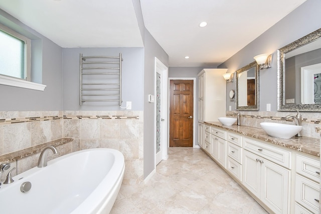 12903 Cluster Pine Dr, Cypress, TX 77429 - full bathroom with radiator heating unit, double vanity, a bath, recessed lighting, and tile walls
