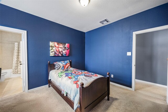 122 Cheswood Forest Dr, Montgomery, TX 77316 - bedroom with carpet, ensuite bath, and a textured ceiling