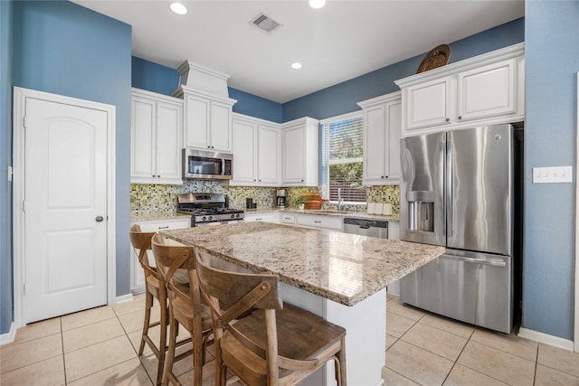 122 Cheswood Forest Dr, Montgomery, TX 77316 - kitchen featuring appliances with stainless steel finishes, backsplash, a center island, white cabinets, and recessed lighting