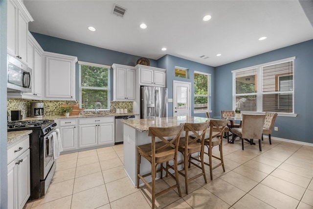 122 Cheswood Forest Dr, Montgomery, TX 77316 - kitchen with stainless steel appliances, tasteful backsplash, light tile patterned flooring, plenty of natural light, and recessed lighting