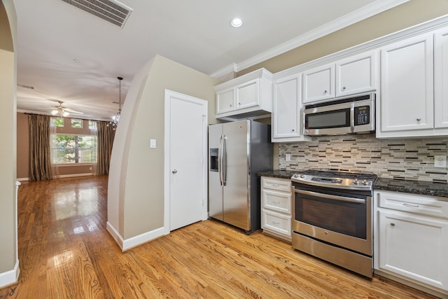 11315 S Main St Unit 1205, Houston, TX 77025 - kitchen featuring appliances with stainless steel finishes, ornamental molding, light wood-type flooring, white cabinets, and tasteful backsplash