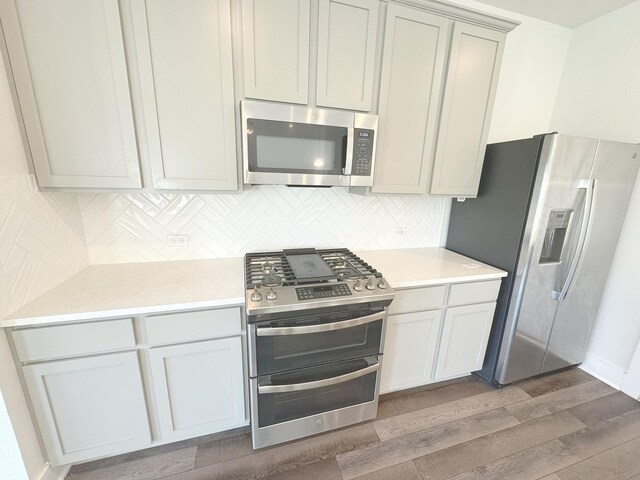 10654 Whitejacket, Conroe, TX 77385 - kitchen with stainless steel appliances, wood finished floors, tasteful backsplash, and light countertops