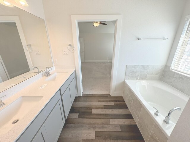 10654 Whitejacket, Conroe, TX 77385 - bathroom with double vanity, a garden tub, a ceiling fan, and wood finished floors