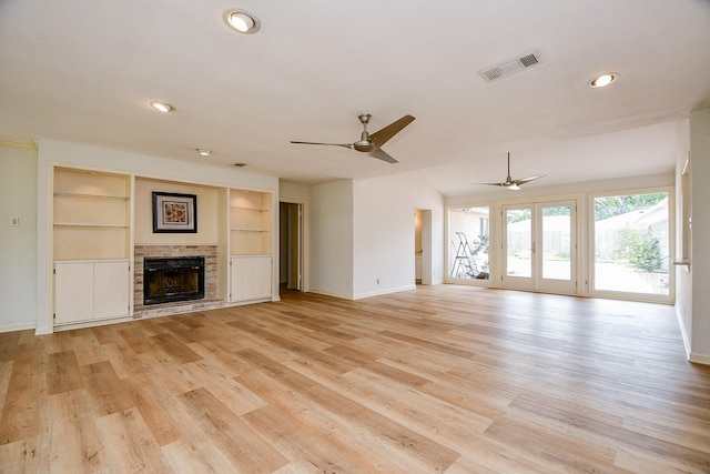 5651 Wigton Dr, Houston, TX 77096 - unfurnished living room featuring baseboards, ceiling fan, a brick fireplace, light wood-style floors, and built in shelves