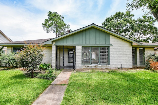 5651 Wigton Dr, Houston, TX 77096 - view of front of property with a front lawn, brick siding, board and batten siding, and roof with shingles