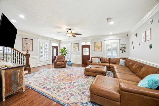 2408 Beall St, Houston, TX 77008 - living area featuring ornamental molding, a ceiling fan, dark wood-style floors, a wainscoted wall, and stairway