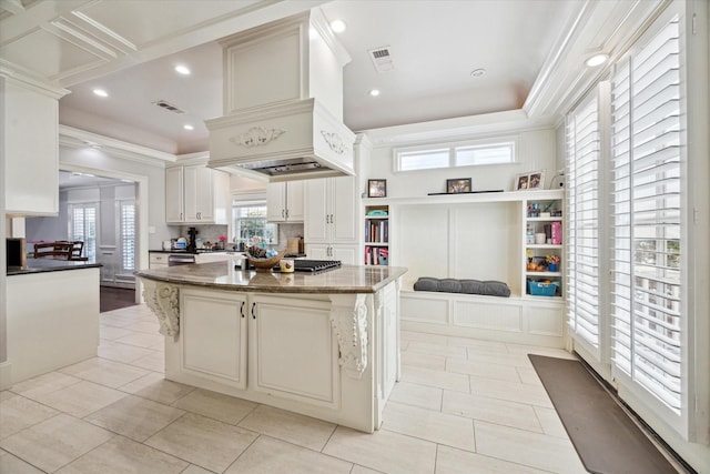2408 Beall St, Houston, TX 77008 - kitchen with a kitchen island, dark stone counters, light tile patterned flooring, recessed lighting, and crown molding