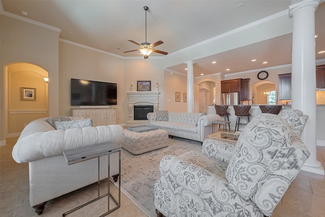 28210 Green Forest Bluff Trl, Katy, TX 77494 - living room featuring decorative columns, ceiling fan, arched walkways, crown molding, and a glass covered fireplace