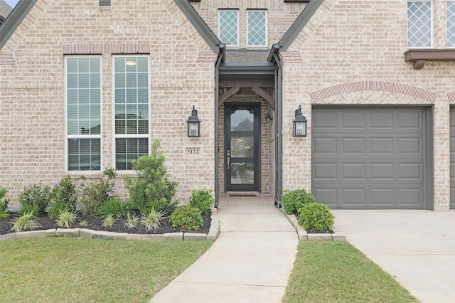 5122 Walnut Grove Ln, Manvel, TX 77578 - doorway to property featuring concrete driveway, an attached garage, and brick siding