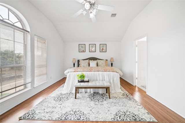 13814 Fort Nelson Dr, Houston, TX 77083 - bedroom with vaulted ceiling, multiple windows, wood finished floors, and a ceiling fan