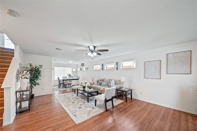 13814 Fort Nelson Dr, Houston, TX 77083 - living area with a ceiling fan, stairway, light wood-type flooring, and baseboards