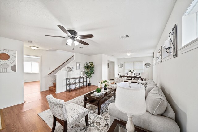 13814 Fort Nelson Dr, Houston, TX 77083 - living room with stairway, ceiling fan, and wood finished floors