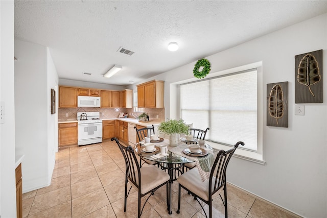 13814 Fort Nelson Dr, Houston, TX 77083 - dining space with light tile patterned floors and a textured ceiling