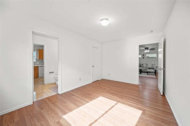 13814 Fort Nelson Dr, Houston, TX 77083 - unfurnished bedroom with light wood-type flooring, baseboards, and ensuite bath