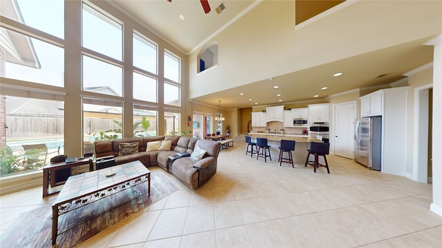 2402 Chesley Park Ct, Katy, TX 77494 - living area with crown molding, a ceiling fan, light tile patterned flooring, a towering ceiling, and recessed lighting