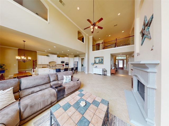 2402 Chesley Park Ct, Katy, TX 77494 - living area featuring a chandelier, ceiling fan, a high ceiling, a tile fireplace, and light tile patterned flooring