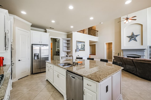 2402 Chesley Park Ct, Katy, TX 77494 - kitchen with stainless steel appliances, a center island with sink, open floor plan, crown molding, and a fireplace