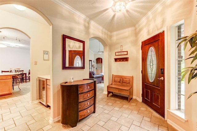 8034 High Hollow Ln, Houston, TX 77070 - foyer entrance featuring wine cooler, ceiling fan, crown molding, light stone finish flooring, and arched walkways
