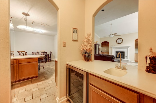 8034 High Hollow Ln, Houston, TX 77070 - kitchen featuring beverage cooler, a ceiling fan, a fireplace with raised hearth, light countertops, and arched walkways
