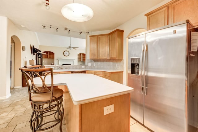 8034 High Hollow Ln, Houston, TX 77070 - kitchen featuring stainless steel fridge, a ceiling fan, arched walkways, light countertops, and backsplash