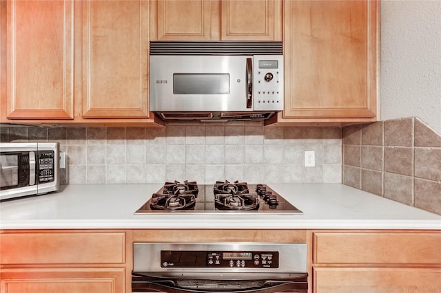 8034 High Hollow Ln, Houston, TX 77070 - kitchen with stainless steel microwave, oven, black gas stovetop, and light countertops