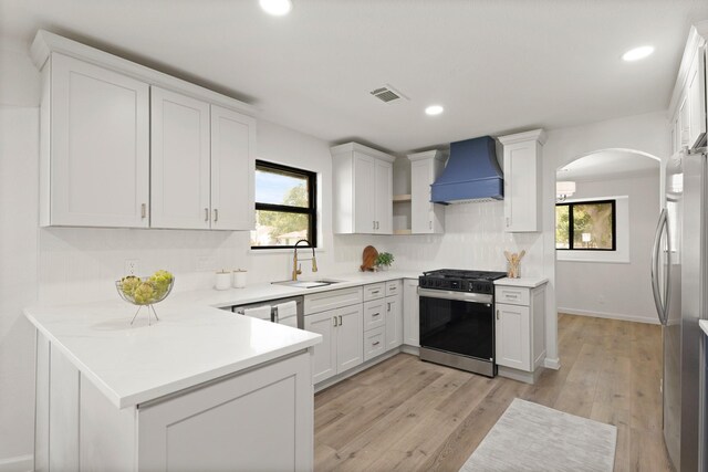 5302 Wigton Dr, Houston, TX 77096 - kitchen featuring gas stove, custom exhaust hood, freestanding refrigerator, plenty of natural light, and recessed lighting