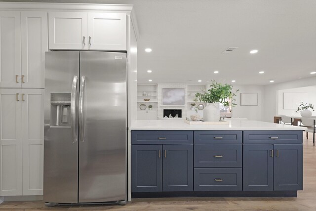 5302 Wigton Dr, Houston, TX 77096 - kitchen featuring stainless steel refrigerator with ice dispenser, white cabinets, recessed lighting, light countertops, and light wood finished floors