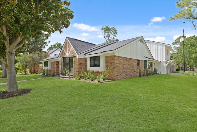 5302 Wigton Dr, Houston, TX 77096 - view of front facade featuring brick siding, a front lawn, a shingled roof, and board and batten siding