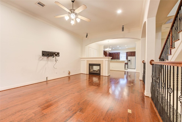7115 Laguna Villas, Houston, TX 77036 - unfurnished living room with ceiling fan, crown molding, hardwood / wood-style floors, arched walkways, and a chandelier