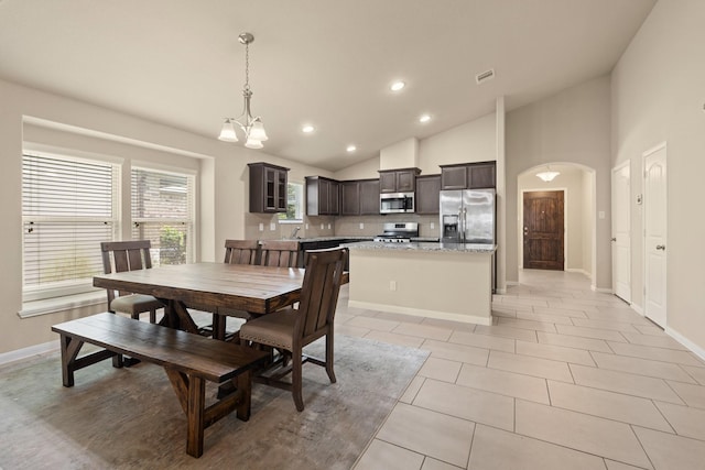 19110 Macallan Ln, Katy, TX 77449 - dining space with lofted ceiling, recessed lighting, arched walkways, a chandelier, and light tile patterned floors