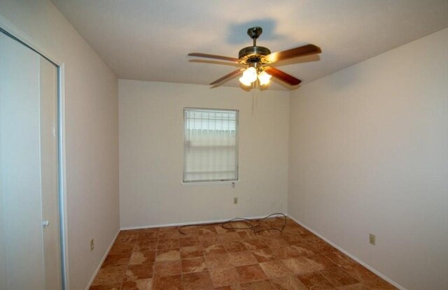 5523 Fair Forest Dr, Houston, TX 77088 - spare room featuring ceiling fan and baseboards
