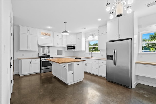 25460 W Fm 1097th Rd, Montgomery, TX 77356 - kitchen featuring appliances with stainless steel finishes, butcher block countertops, concrete flooring, white cabinetry, and recessed lighting