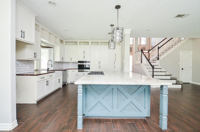 16210 S Temple Dr, Houston, TX 77095 - kitchen with stainless steel appliances, backsplash, dark wood-style floors, a kitchen island, and white cabinets