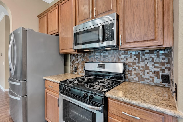 1431 Hidden Terrace Dr, Sugar Land, TX 77479 - kitchen featuring stainless steel appliances, backsplash, light stone counters, wood finished floors, and ornamental molding