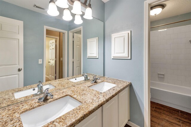 1431 Hidden Terrace Dr, Sugar Land, TX 77479 - bathroom featuring double vanity, wood finished floors, and bathtub / shower combination