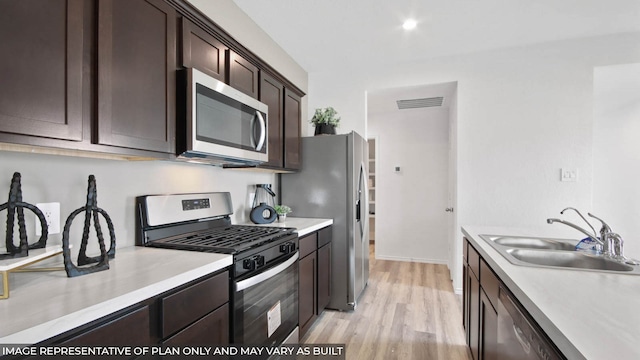 5446 Pinetree Crescent Ln, Spring, TX 77373 - kitchen featuring appliances with stainless steel finishes, dark brown cabinetry, light countertops, and light wood-style flooring