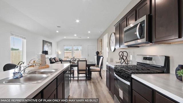 5446 Pinetree Crescent Ln, Spring, TX 77373 - kitchen with appliances with stainless steel finishes, light wood finished floors, light countertops, dark brown cabinets, and recessed lighting