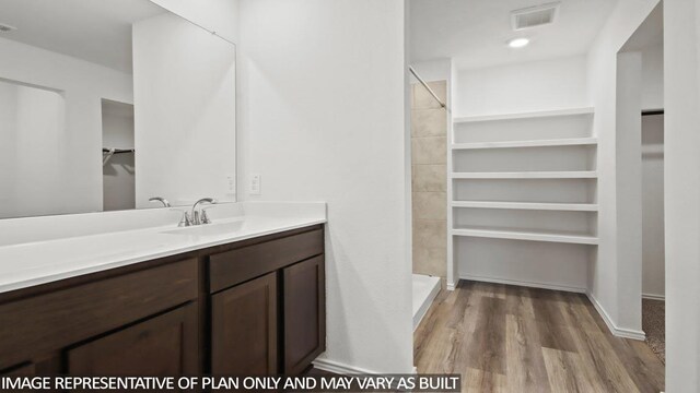 5446 Pinetree Crescent Ln, Spring, TX 77373 - bathroom with wood finished floors, a walk in closet, vanity, and tiled shower