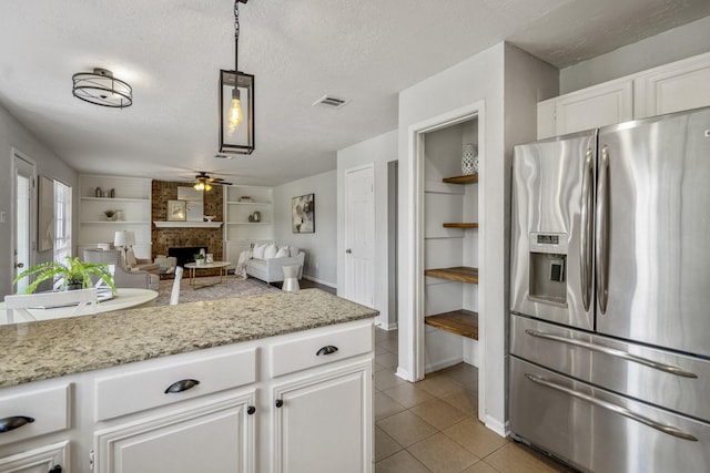 8415 Sparkling Springs Dr, Houston, TX 77095 - kitchen featuring stainless steel refrigerator with ice dispenser, a ceiling fan, built in features, light tile patterned floors, and white cabinetry