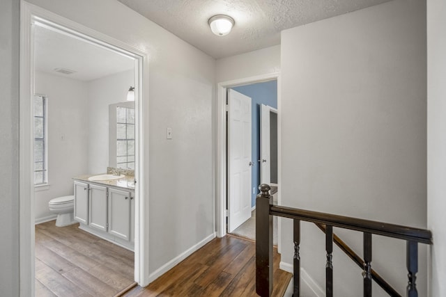 8415 Sparkling Springs Dr, Houston, TX 77095 - hallway featuring an upstairs landing, dark wood-style floors, and a textured ceiling