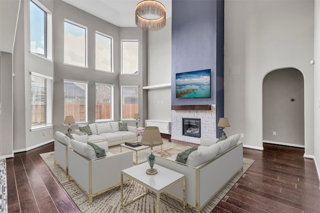 4511 Hickory Branch Ln, Sugar Land, TX 77479 - living area with hardwood / wood-style flooring, arched walkways, a high ceiling, and a large fireplace