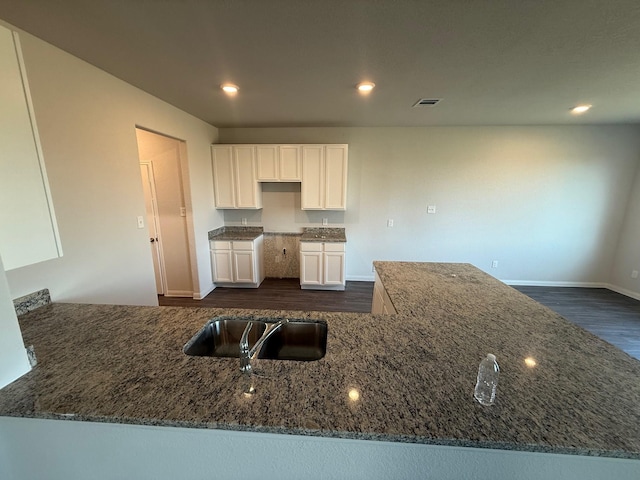 2576 Hawks Eye Dr, Conroe, TX 77301 - kitchen featuring dark stone countertops, dark wood-style floors, white cabinetry, and recessed lighting