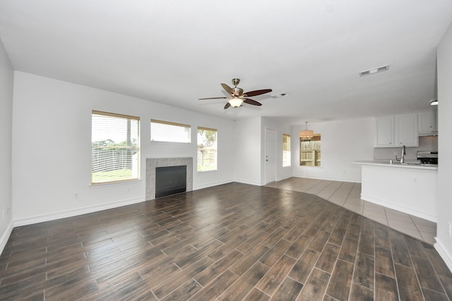 9226 Wichita Dr, La Porte, TX 77571 - unfurnished living room featuring a ceiling fan, wood finished floors, and a tiled fireplace