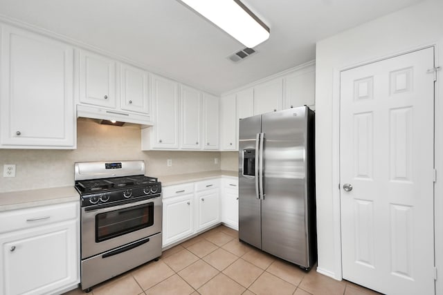 9226 Wichita Dr, La Porte, TX 77571 - kitchen with appliances with stainless steel finishes, under cabinet range hood, light tile patterned floors, and light countertops