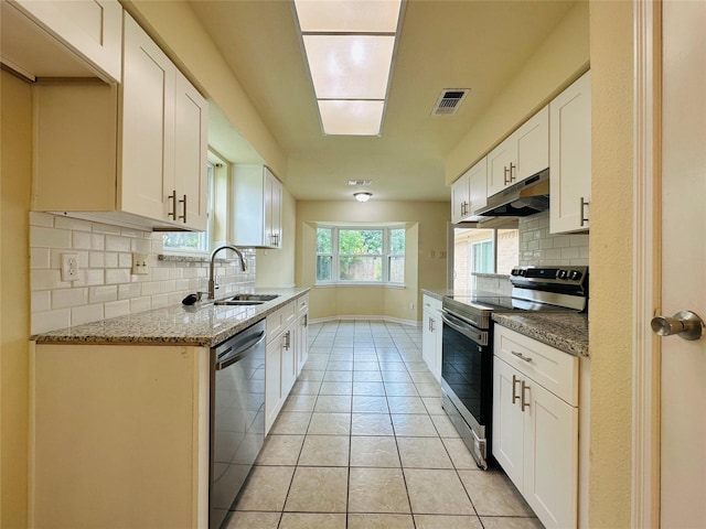 15474 Peermont St, Houston, TX 77062 - kitchen with stainless steel appliances, under cabinet range hood, decorative backsplash, light tile patterned floors, and light stone countertops