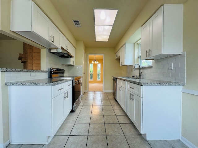 15474 Peermont St, Houston, TX 77062 - kitchen with appliances with stainless steel finishes, backsplash, light stone countertops, range hood, and white cabinetry