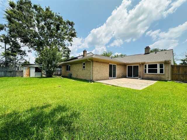 15474 Peermont St, Houston, TX 77062 - back of property featuring a chimney, a patio, a fenced backyard, and brick siding