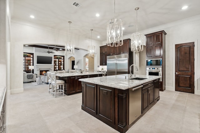 5201 Pine St, Bellaire, TX 77401 - kitchen featuring built in appliances, a spacious island, arched walkways, open floor plan, and ceiling fan