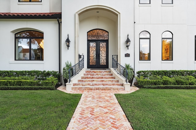 5201 Pine St, Bellaire, TX 77401 - doorway to property featuring stucco siding, a yard, and a porch